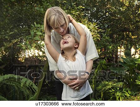 Stock Photograph - Girl hugging mother. Fotosearch