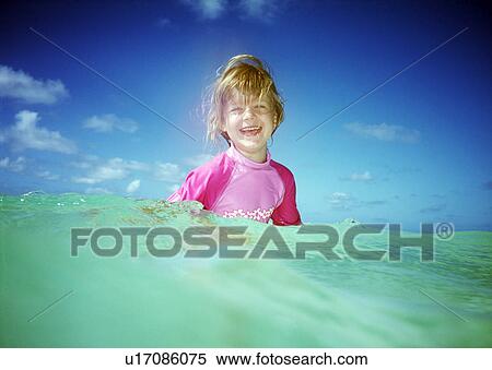 Stock Photography - Girl in sea, looking at camera. Fotosearch