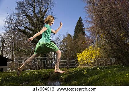 girl jumping over creek View Large Photo Image Stock Image - girl jumping over creek. Fotosearch