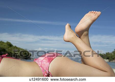 Stock Image - Girl laying on beach. Fotosearch