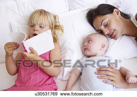 Girl reading a book to her baby brother View Large Photo Image Stock Photo - Girl reading a book to her baby brother. Fotosearch