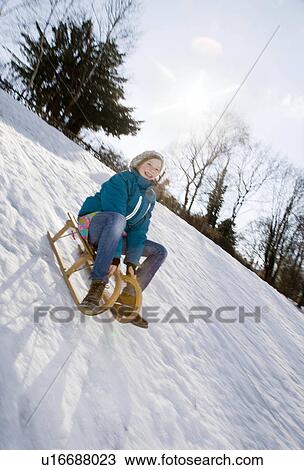 Girl riding a sledge in snow View Large Photo Image Stock Image - Girl riding a sledge in snow. Fotosearch