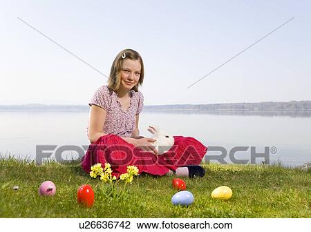Stock Image - girl with bunny and easter eggs. Fotosearch
