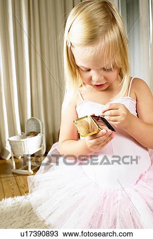 Stock Image - Girl with costume, putting on make up. Fotosearch