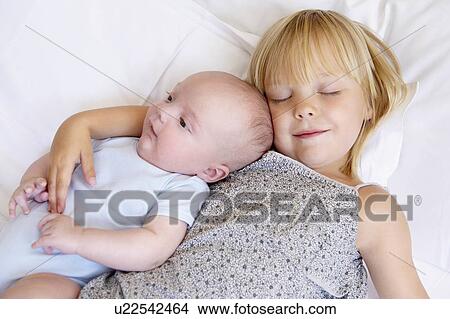 Girl with her baby brother in bed View Large Photo Image Picture - Girl with her baby brother in bed. Fotosearch