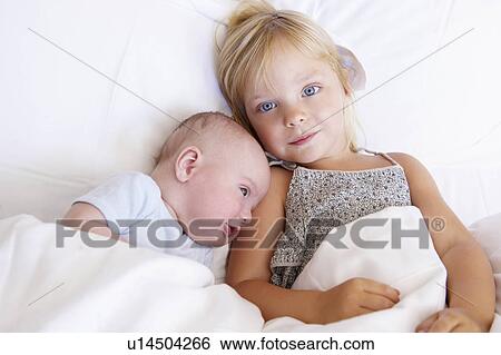 Girl with her baby brother in bed View Large Photo Image Stock Photograph - Girl with her baby brother in bed. Fotosearch