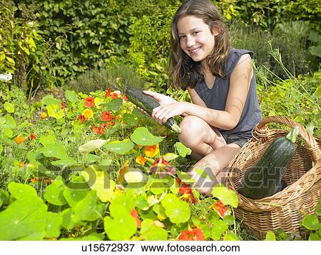 Girl working in her vegetable garden View Large Photo Image Stock Photo - Girl working in her vegetable garden. Fotosearch