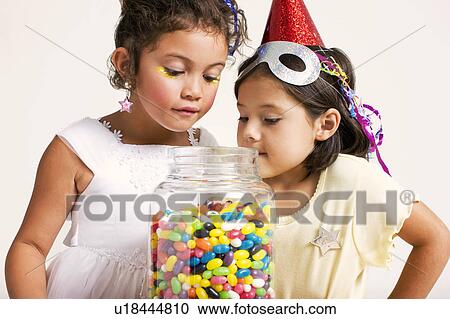 Stock Image - girls looking at sweet jar. Fotosearch