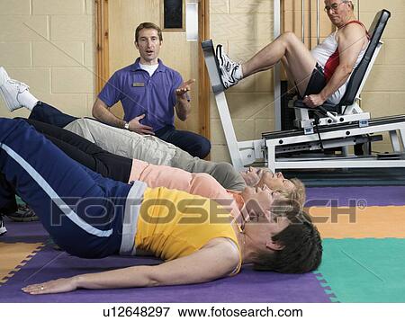 Stock Photo - group training at gym with instructor. Fotosearch