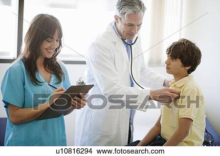Male Doctor and female nurse helping boy View Large Photo Image Picture - Male Doctor and female nurse helping boy. Fotosearch