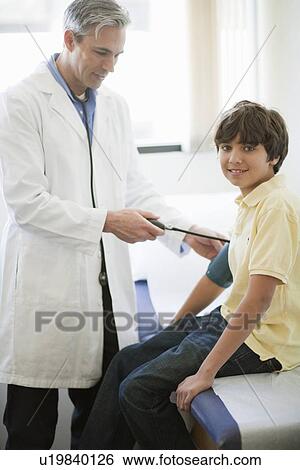 Male Doctor examining boy patient View Large Photo Image Stock Photograph - Male Doctor examining boy patient. Fotosearch