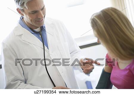 Male Doctor examining girl patient View Large Photo Image Picture - Male Doctor examining girl patient. Fotosearch