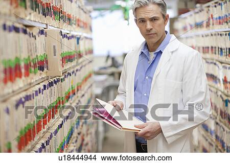 Male Doctor holding medical file View Large Photo Image Picture - Male Doctor holding medical file. Fotosearch