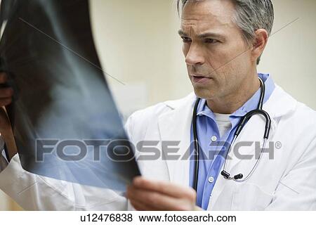 Male Doctor looking at x-ray View Large Photo Image Stock Photo - Male Doctor looking at x-ray. Fotosearch