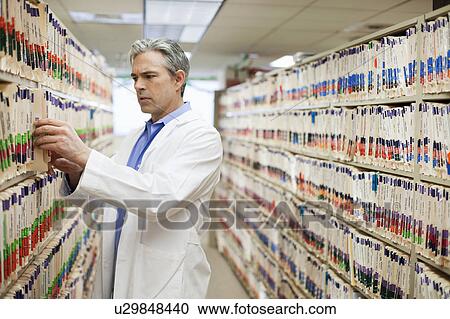 Male Doctor searching medical files View Large Photo Image Stock Image - Male Doctor searching medical files. Fotosearch