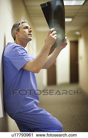 Male Surgeon looking at x-ray View Large Photo Image Stock Image - Male Surgeon looking at x-ray. Fotosearch