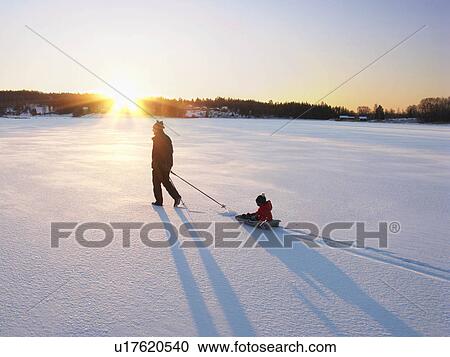 Stock Image - Man and boy on snow. Fotosearch