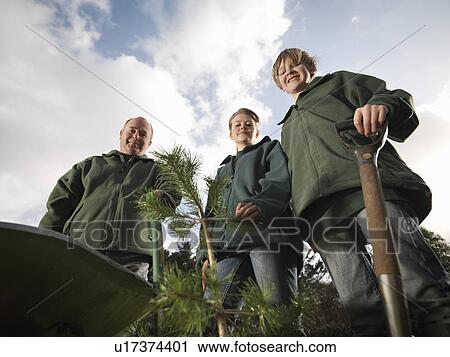 Stock Image - Man And Children With Young Trees. Fotosearch