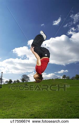 Picture - man backflipping in park. Fotosearch