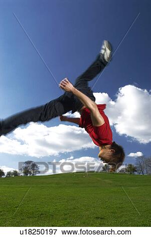 Stock Photo - man backflipping in park. Fotosearch