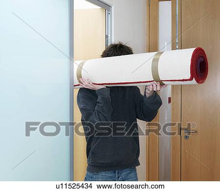 Man carrying rolled rug View Large Photo Image Picture - Man carrying rolled rug. Fotosearch