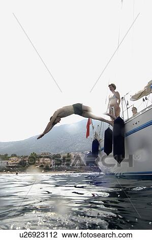 Man diving into water from sailing boat View Large Photo Image Stock Image - Man diving into water from sailing boat. Fotosearch