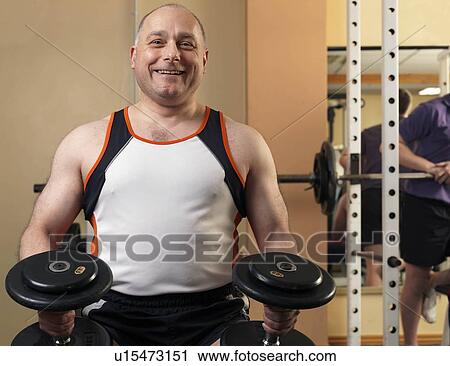 man exercising with weights at gym View Large Photo Image Stock Image - man exercising with weights at gym. Fotosearch