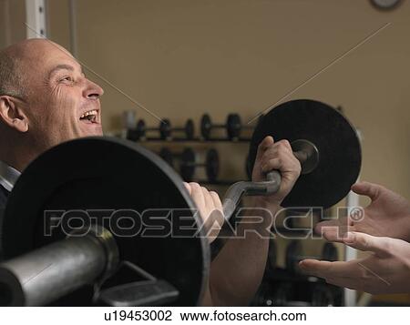 man exercising with weights at gym View Large Photo Image Stock Image - man exercising with weights at gym. Fotosearch