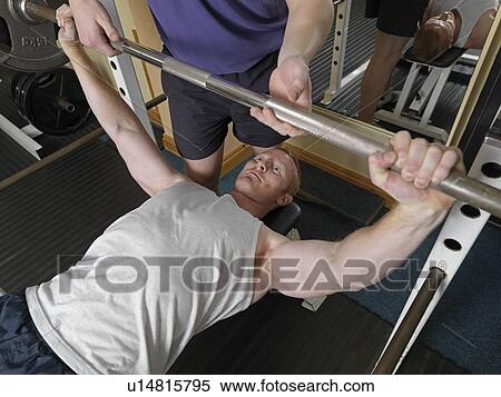 Stock Photography - man exercising with weights at gym. Fotosearch