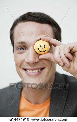 man holding a toy ball in front of eye View Large Photo Image Stock Image - man holding a toy ball in front of eye. Fotosearch