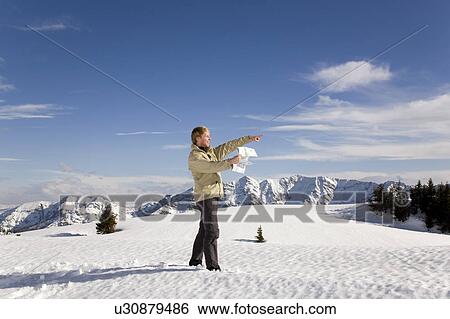Stock Photograph - man in mountains pointing with map. Fotosearch