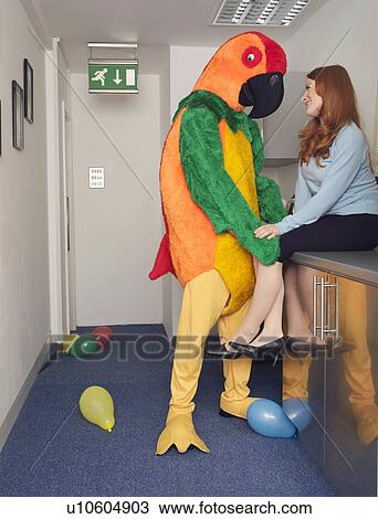 Stock Image - Man in parrot outfit with co worker. Fotosearch