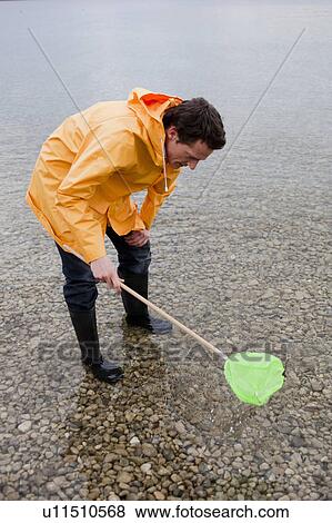man in raincoat fishing with toy net View Large Photo Image Stock Photo - man in raincoat fishing with toy net. Fotosearch