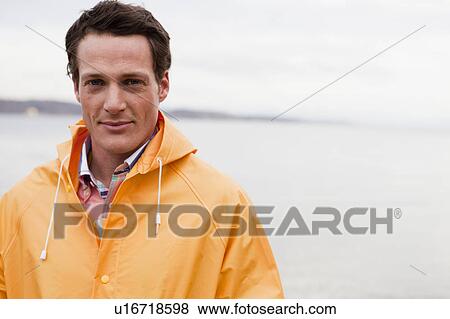 Stock Photo - man in raincoat looking at viewer. Fotosearch