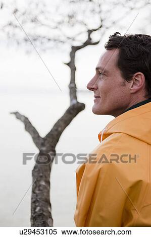 man in raincoat looking on a lake View Large Photo Image Stock Photography - man in raincoat looking on a lake. Fotosearch