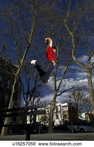 Stock Photo - man jumping over bench. Fotosearch