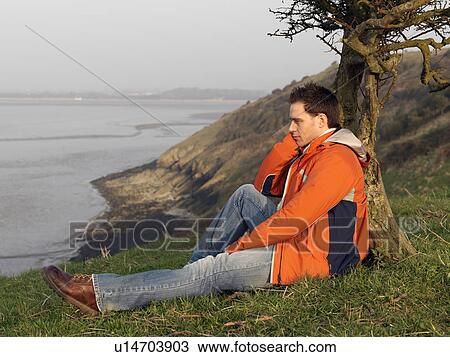 Stock Image - man looking across sea. Fotosearch