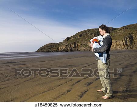 man on beach holding baby View Large Photo Image Stock Photography - man on beach holding baby. Fotosearch