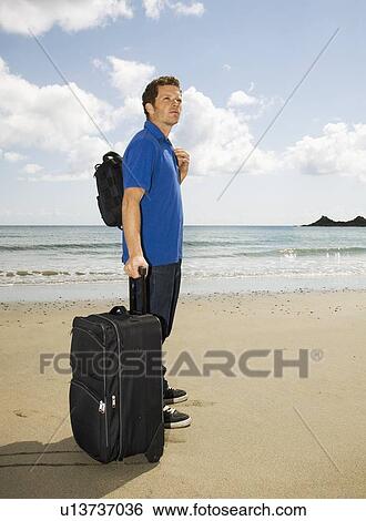 Stock Photograph - Man on Beach with Case. Fotosearch