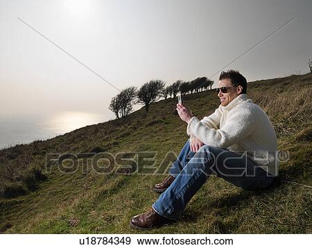man on phone on coastal hill View Large Photo Image Stock Photo - man on phone on coastal hill. Fotosearch
