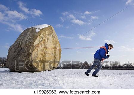 Stock Image - Man pulling boulder. Fotosearch
