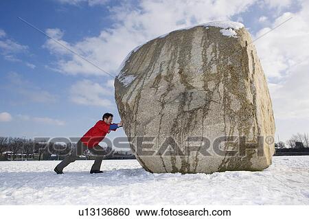 Stock Image - Man pushing boulder. Fotosearch