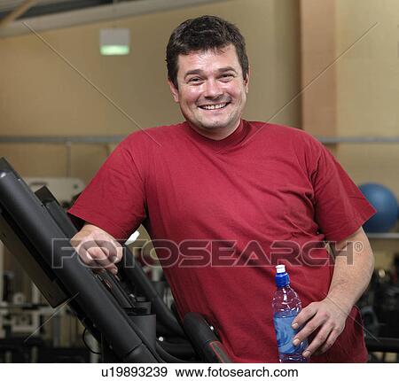 man relaxing on running machines at gym View Large Photo Image Stock Photo - man relaxing on running machines at gym. Fotosearch