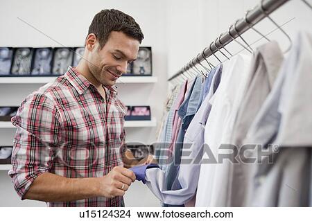 man shopping holding a shirt's sleeve View Large Photo Image Picture - man shopping holding a shirt's sleeve. Fotosearch