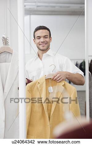 man shopping holding up jacket View Large Photo Image Stock Image - man shopping holding up jacket. Fotosearch