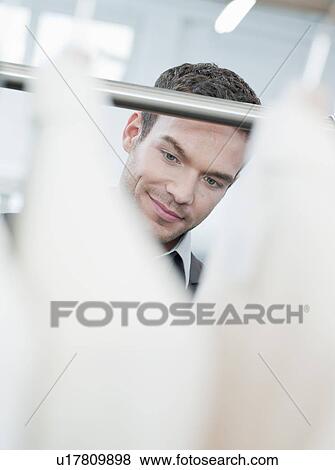man shopping looking at jackets View Large Photo Image Stock Photo - man shopping looking at jackets. Fotosearch