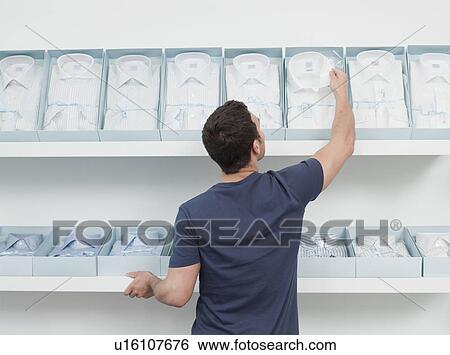 man shopping looking at shirts View Large Photo Image Stock Photograph - man shopping looking at shirts. Fotosearch