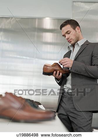 Stock Photo - man shopping looking at shoe. Fotosearch