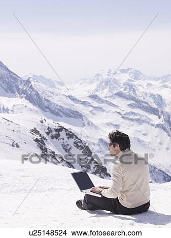 man sitting in the snow using laptop View Large Photo Image Picture - man sitting in the snow using laptop. Fotosearch
