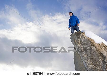 man standing on snow covered peak View Large Photo Image Stock Image - man standing on snow covered peak. Fotosearch